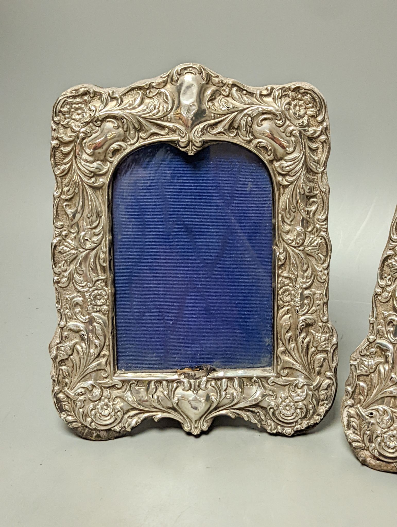A pair of Edwardian repousse silver mounted photograph frames, Sydney & Co, Birmingham, 1902, 22.5cm (a.f.).